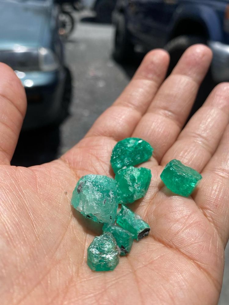 Esmeraldas en bruto recién extraídas en la palma de la mano